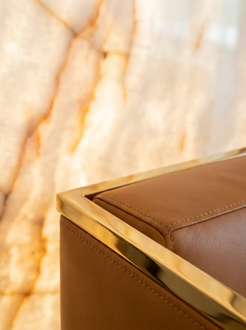 Sự phối hợp đắt giá giữa đá xuyên sáng Onyx và sofa da bò Ý giúp nâng tầm đẳng cấp cho toàn bộ không gian đón khách.